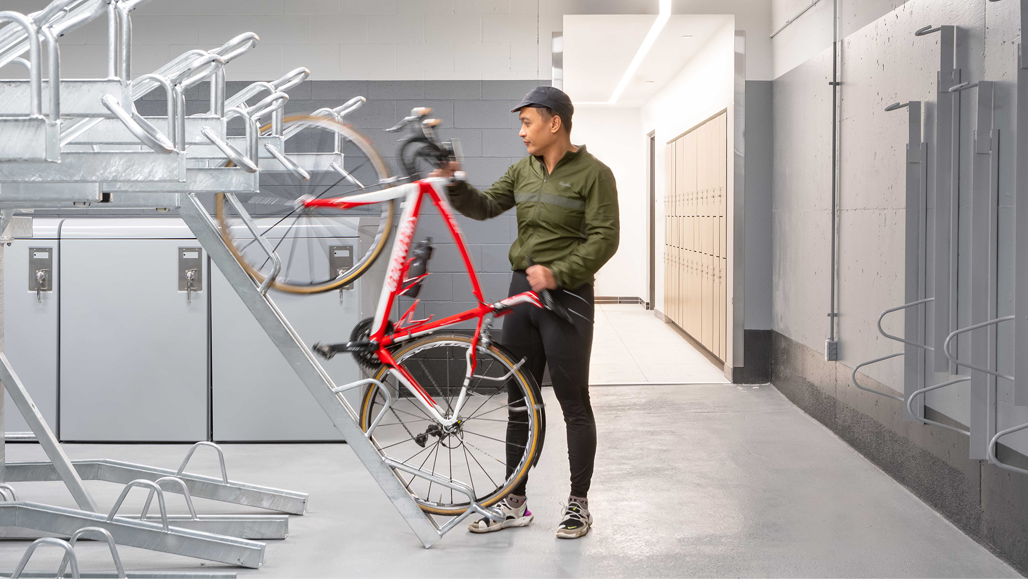 Image showing a man placing a bicycle in a horizontal double-stacked bike storage unit.